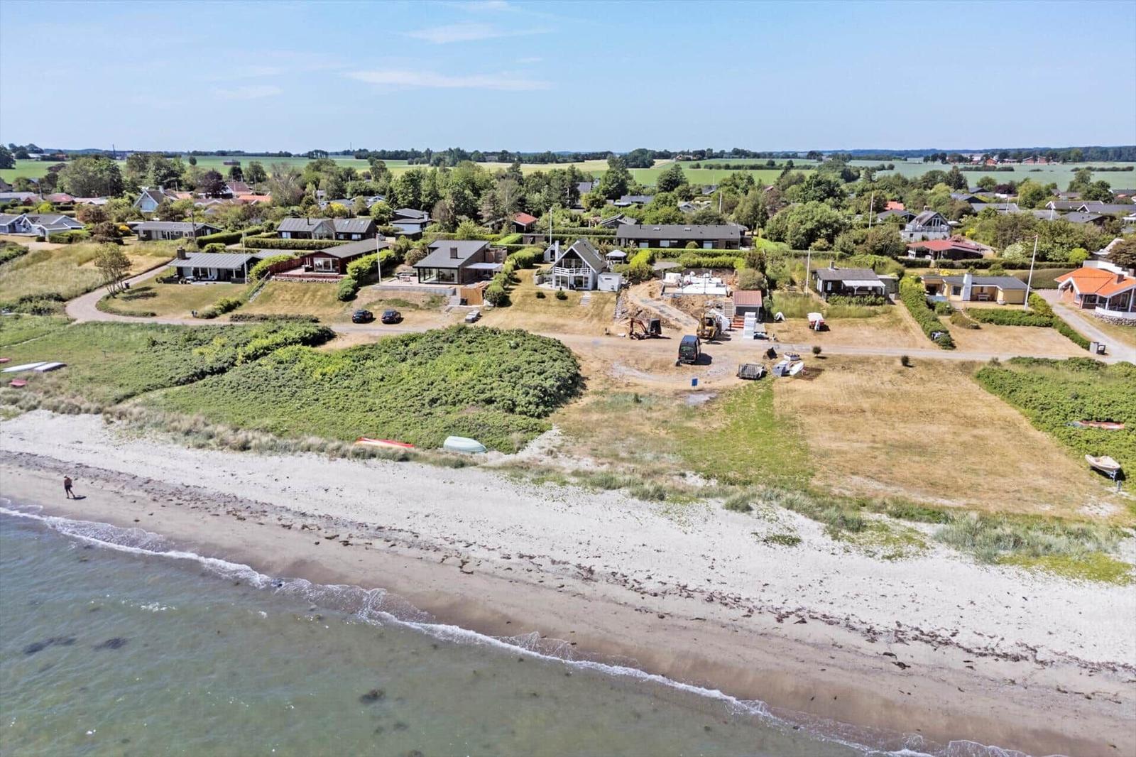 Houses near beach with construction site and green areas