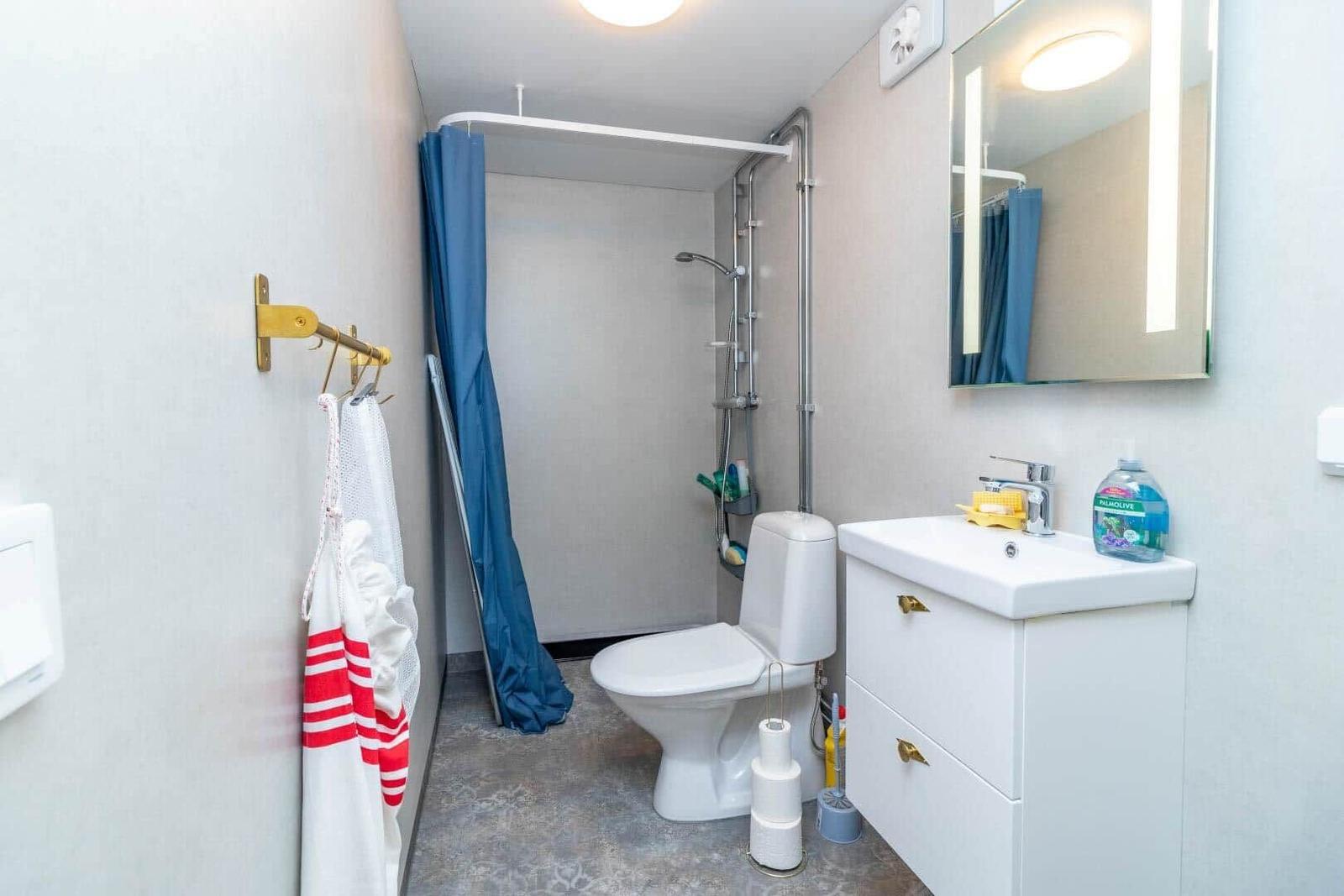 Badezimmer mit Dusche, Toilette und Waschbecken.