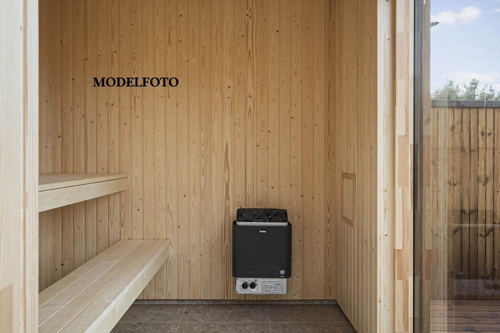 Sauna mit Holzwand und Sitzbank, Heizung mit Steinen.