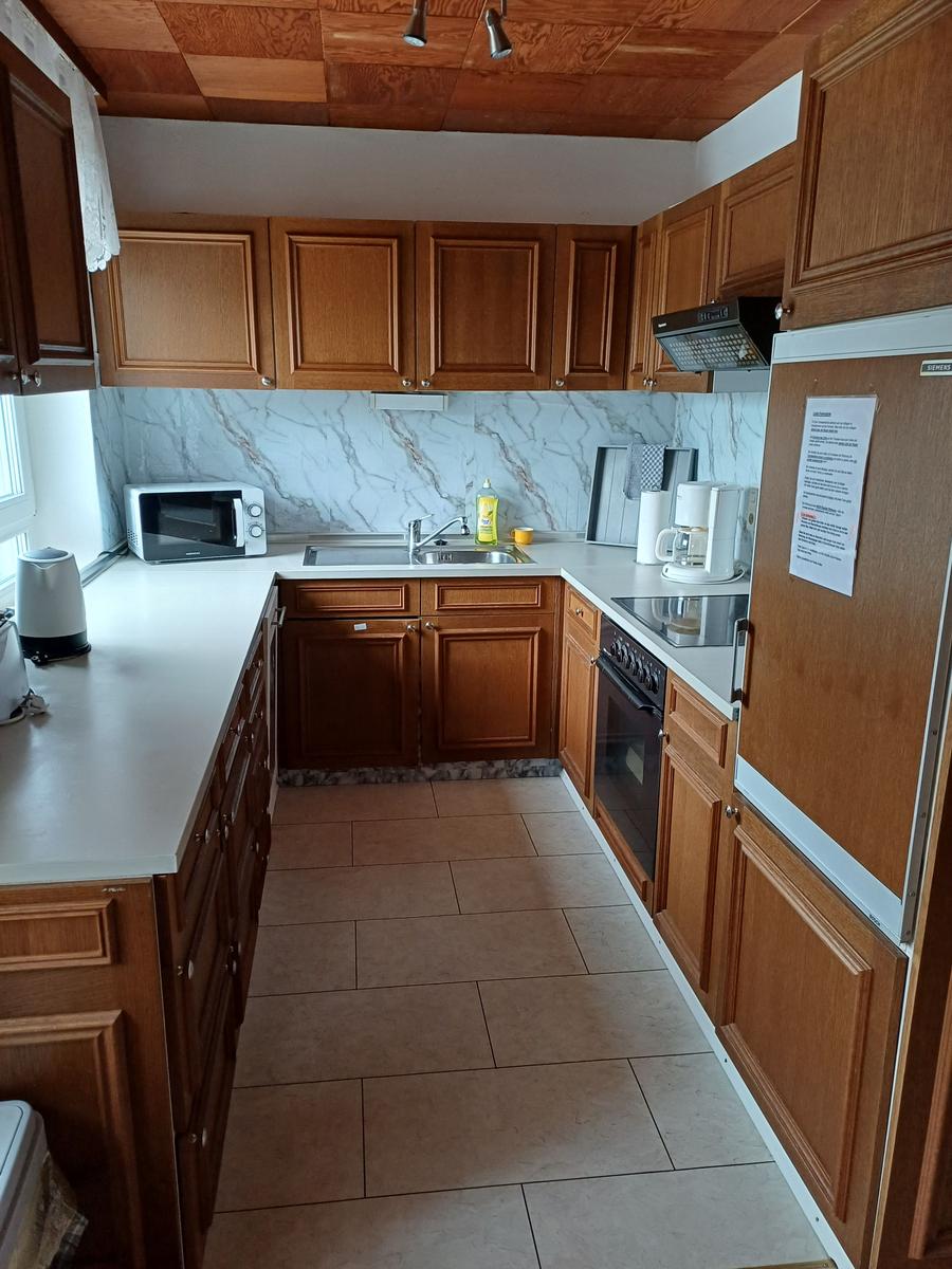 Küche mit Mikrowelle, Cerankochfel, Kühlschrank mit Grierfach und  Backofen.