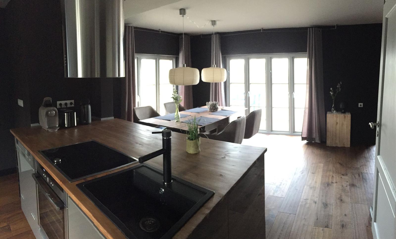 Küche mit Essbereich, Holzboden und großen Fenstern.