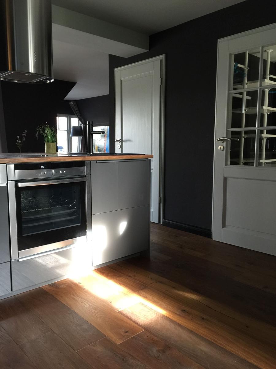 Moderne Küche mit Edelstahlherd und Holzboden.