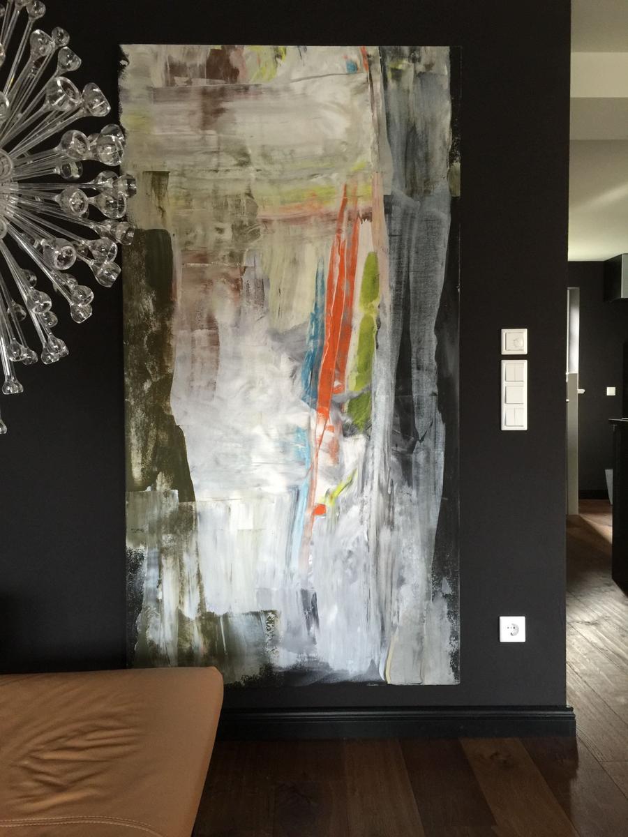 Großes abstraktes Gemälde an schwarzer Wand. Glasleuchte und brauner Sitzbereich.