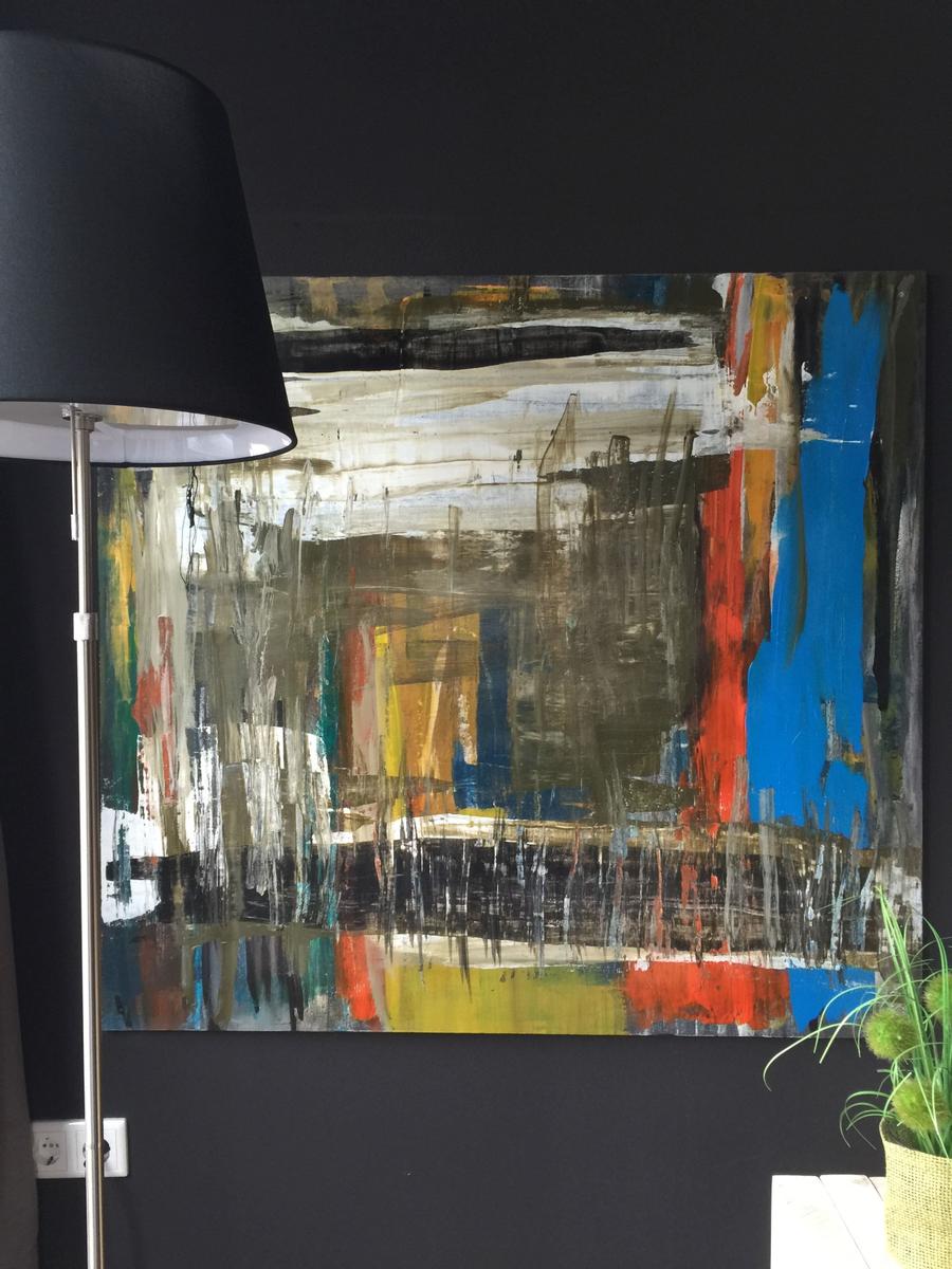 Großes abstraktes Gemälde an dunkler Wand neben Stehlampe und Pflanze.
