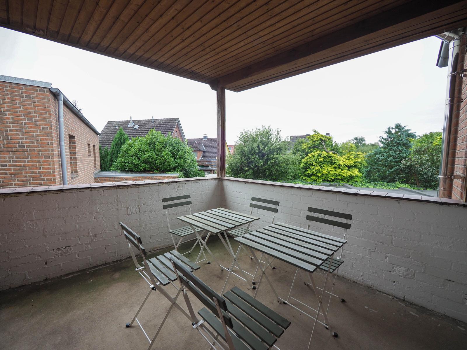 Terrasse mit Tisch und Stühlen unter Dach