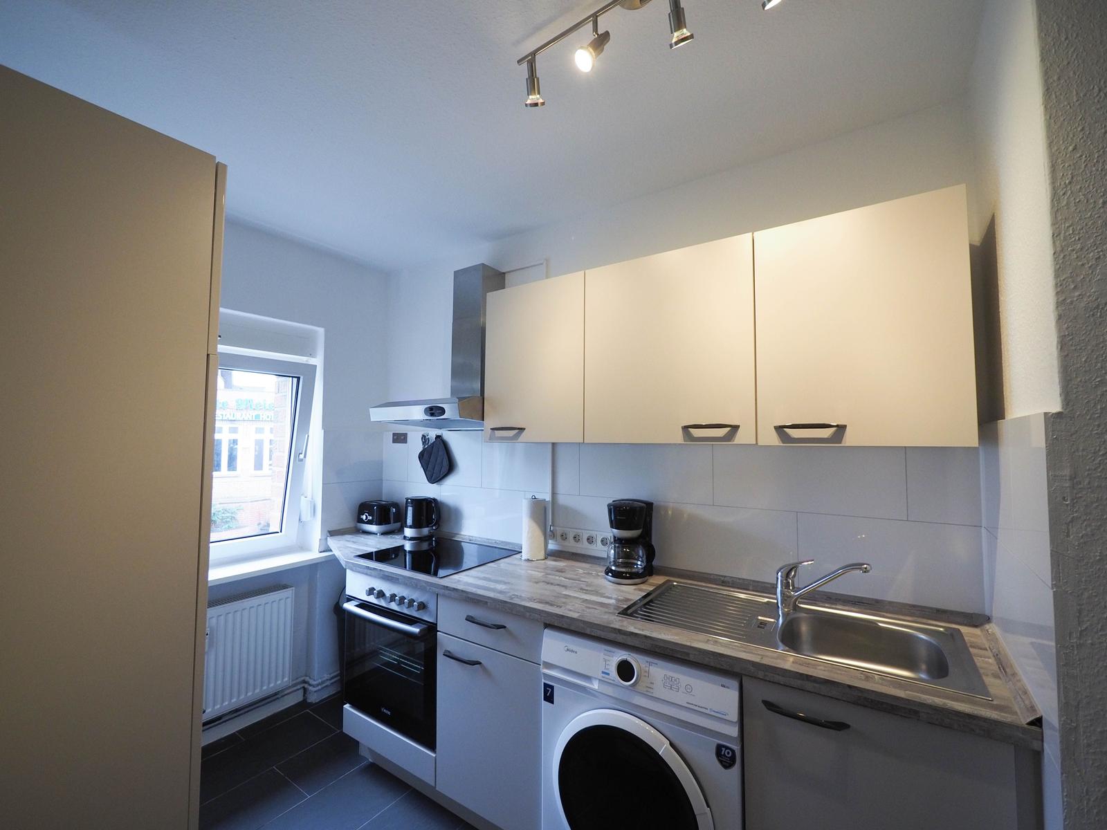 Küche mit Spüle, Kochfeld und Waschmaschine