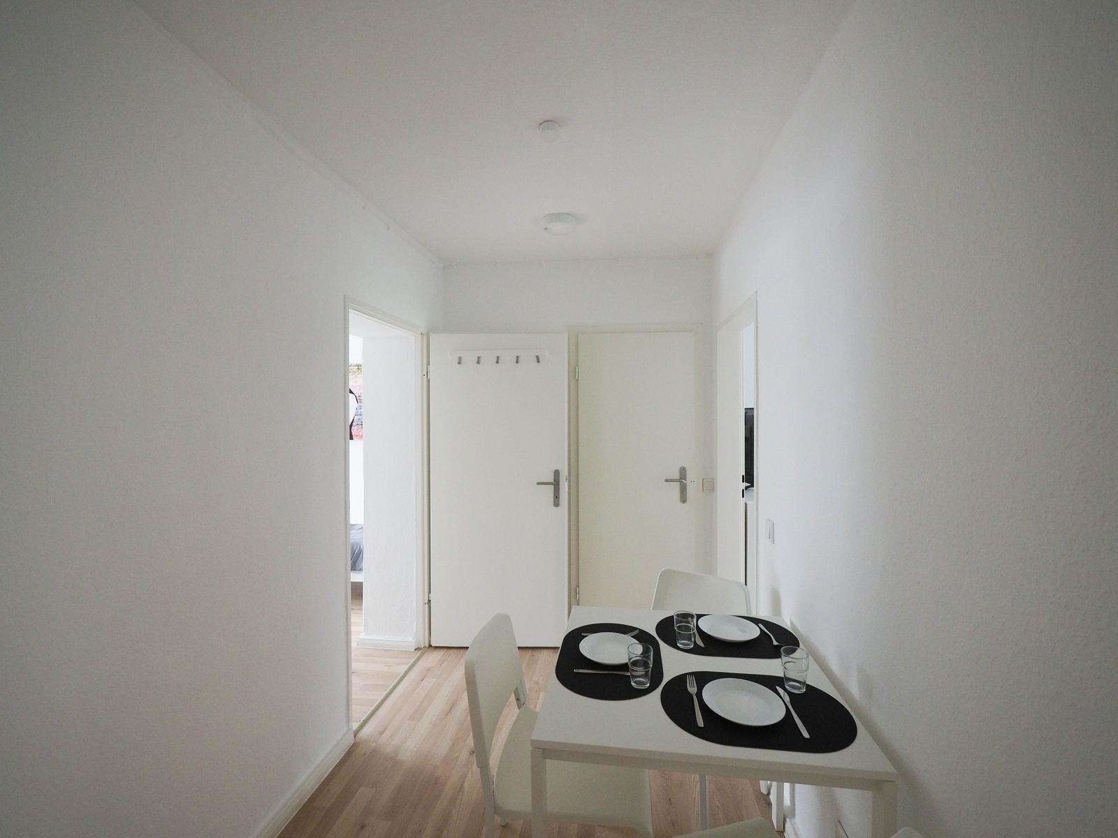 Essbereich mit Tisch und Stühlen, Blick in angrenzende Räume.