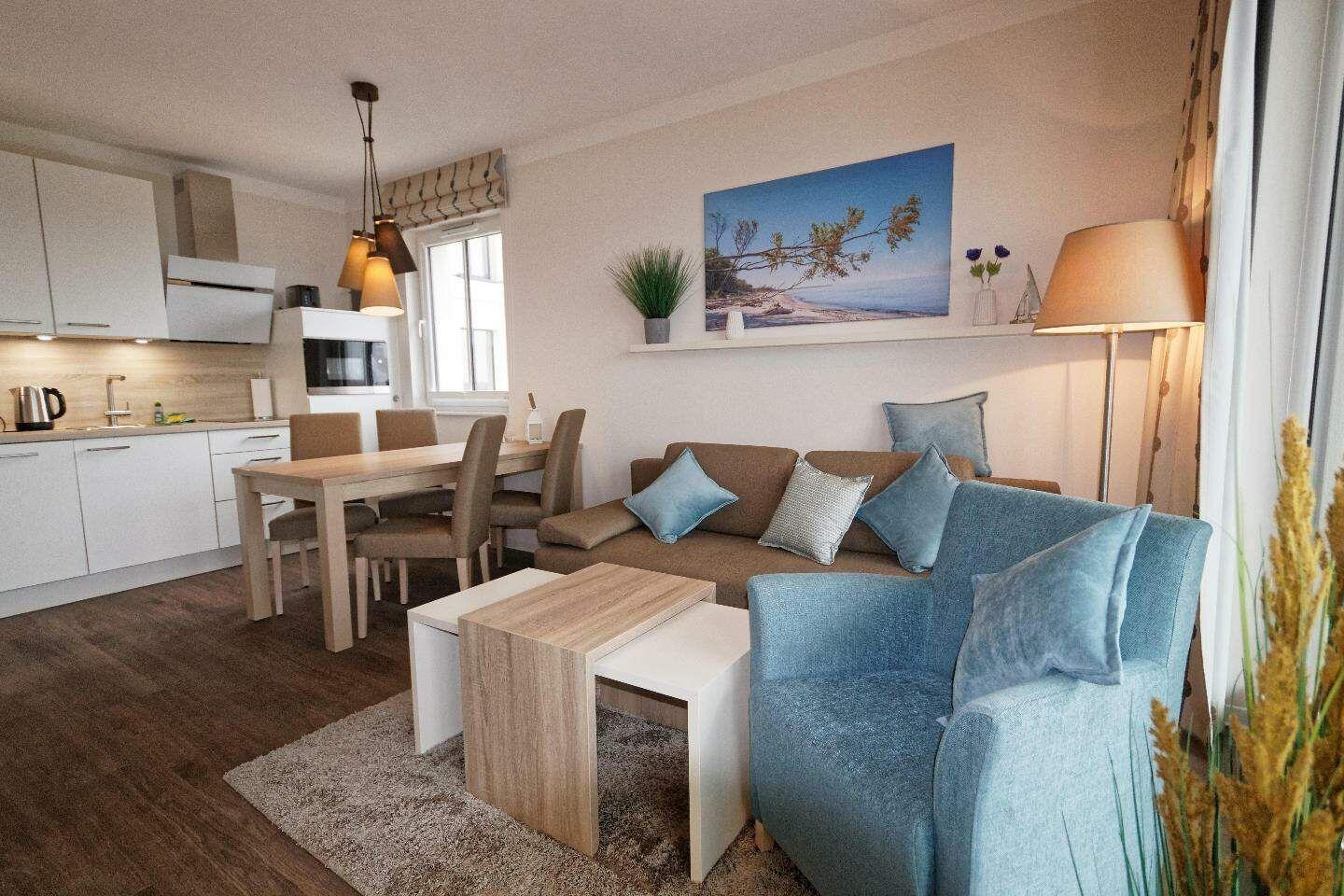 Wohn- und Essbereich mit Sofa, Sitzgelegenheit und Küchenzeile.