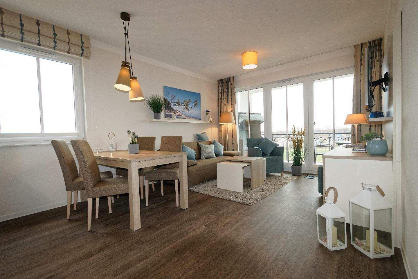 Wohn- und Essbereich mit Tisch, Stühlen, Sofa und Blick auf Balkon.