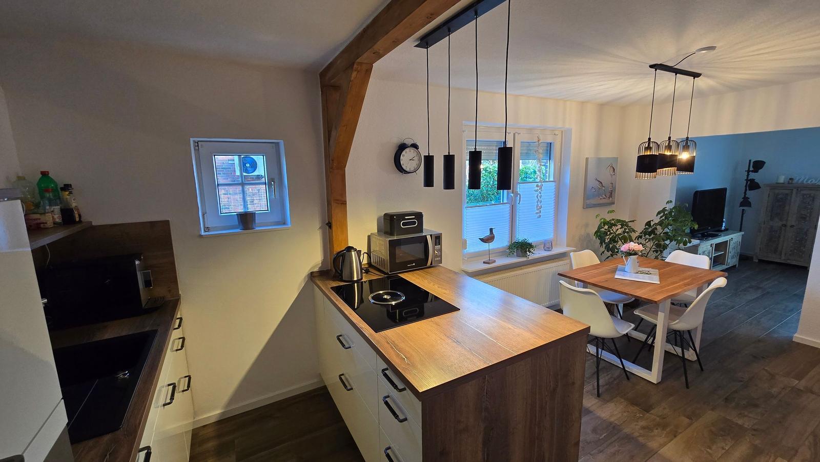 Küche mit Essbereich und Wohnzimmer im Hintergrund.