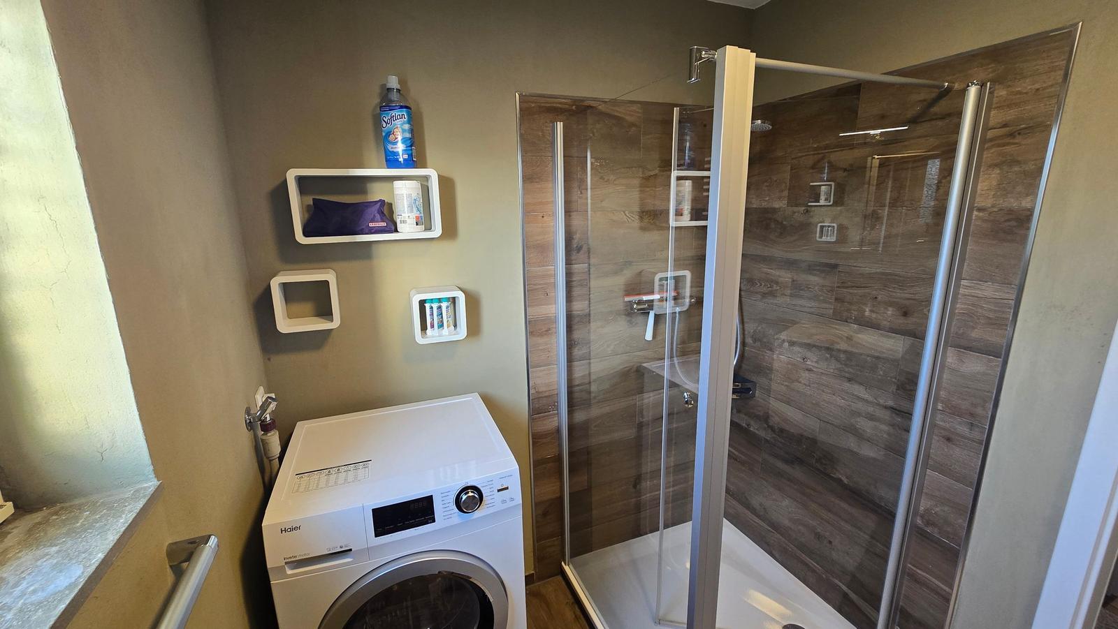 Badezimmer mit Dusche und Waschmaschine
