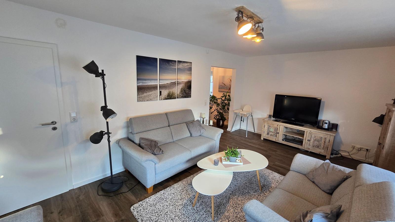 Wohnzimmer mit Sofa, Couchtisch und Fernseher.
