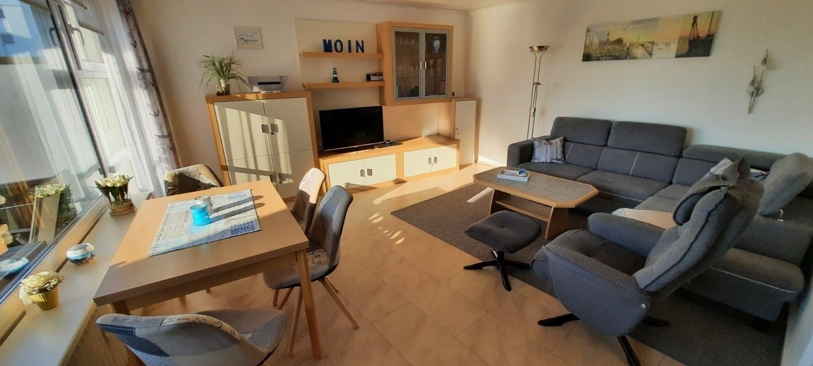 Wohn- und Essbereich mit Sofa, Esstisch und TV-Möbel.