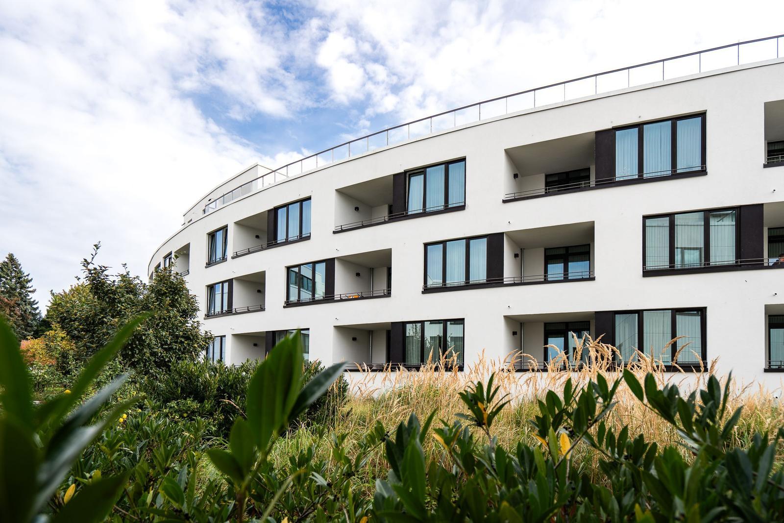 Moderne Wohnanlage mit Balkonen und grüner Umgebung.