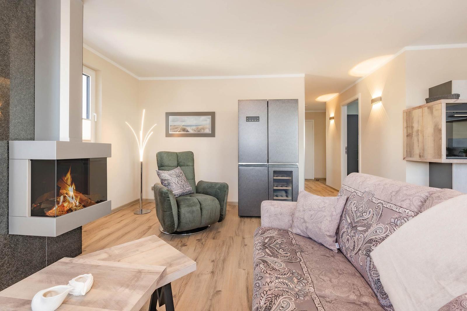 Wohnbereich mit Kamin, Sofa und Kühlschrank.