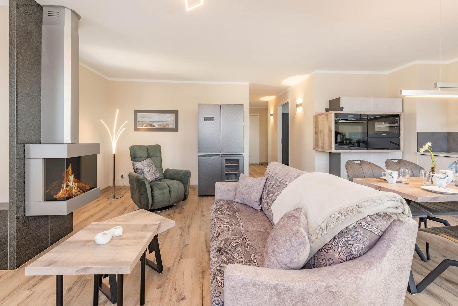 Wohn- und Essbereich mit Kamin, Sofa und Esstisch.