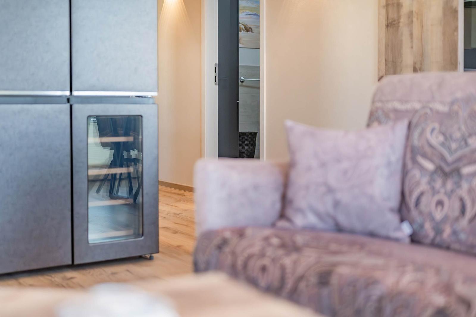 Küche mit Kühlschrank und Sofa im Vordergrund.