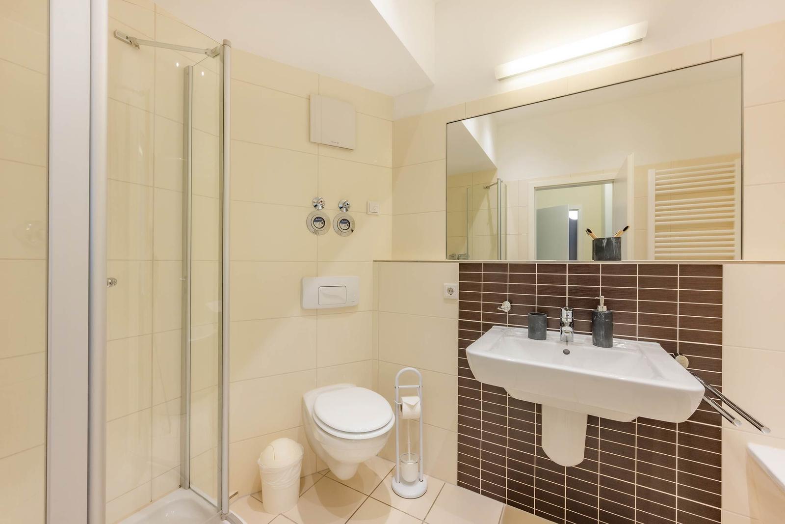 Badezimmer mit Dusche, Toilette und Waschbecken.