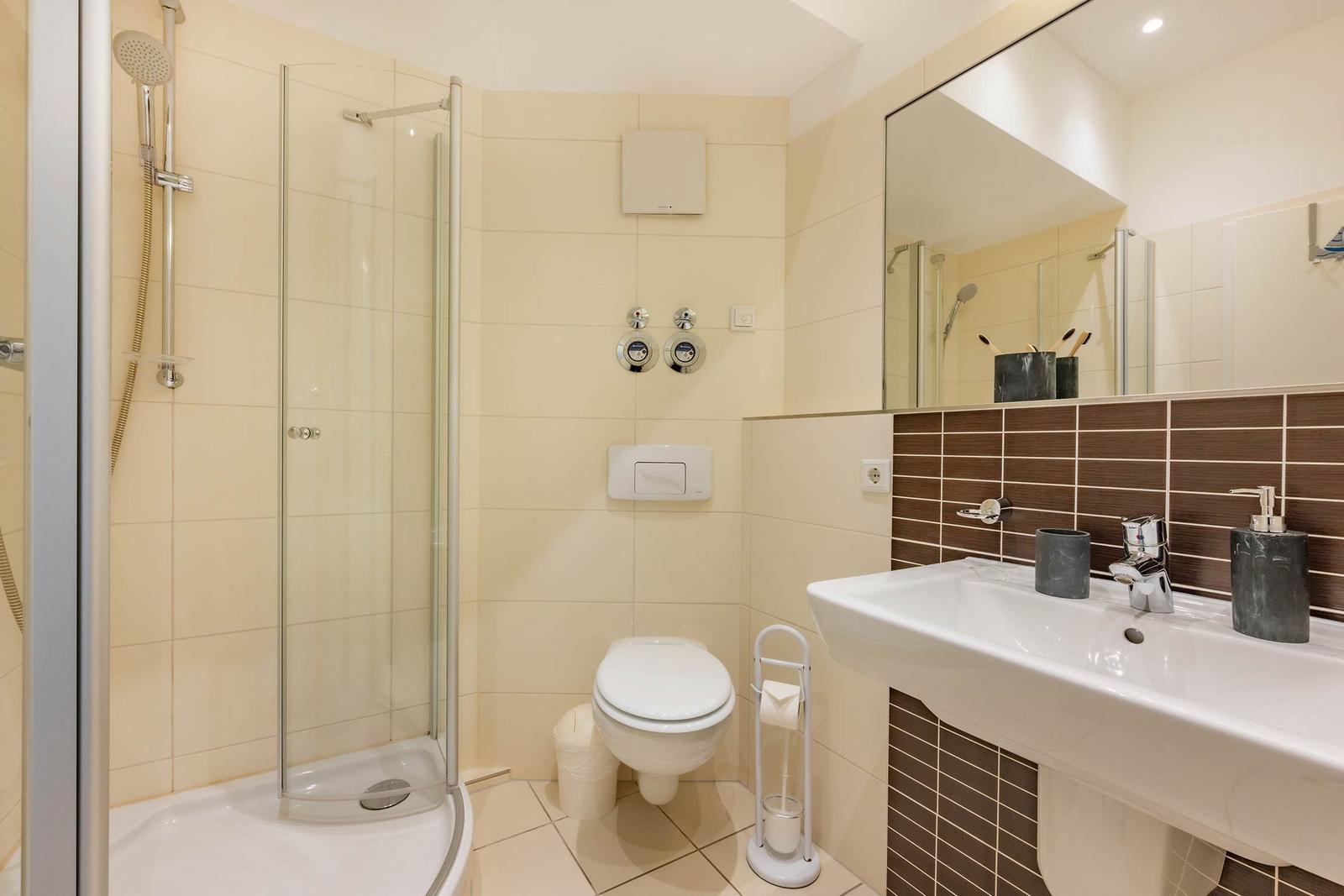 Bad mit Dusche, Toilette und Waschbecken mit Spiegel