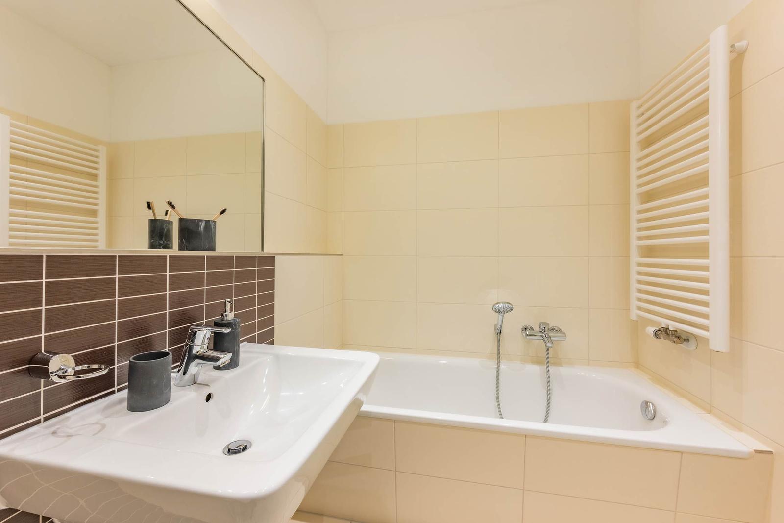 Badezimmer mit Badewanne, Waschbecken und Spiegel