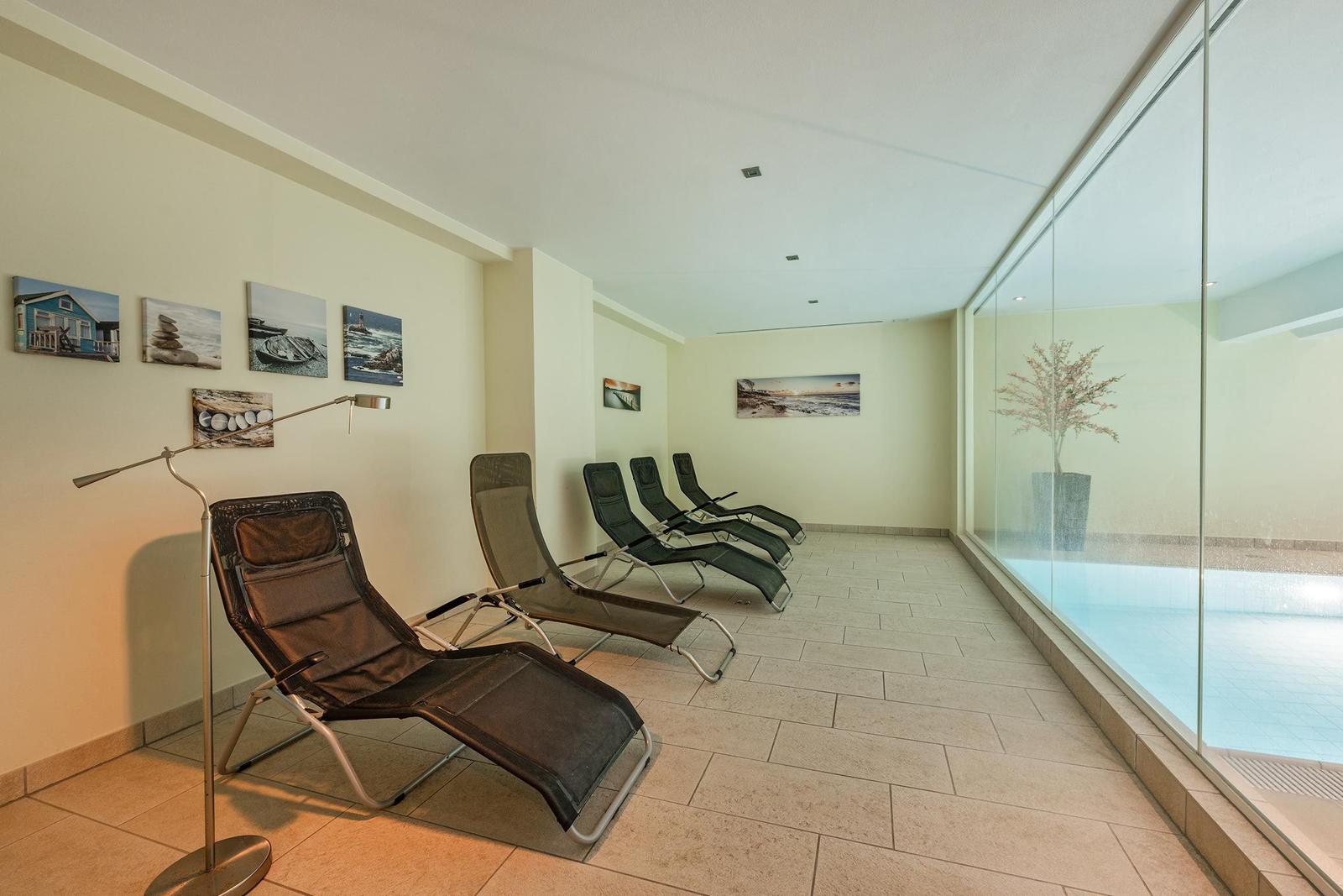 Loungebereich mit Liegen und Blick auf Pool