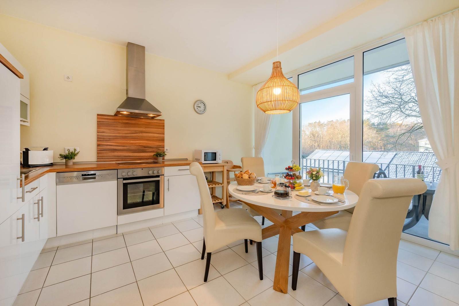 Küche mit Essbereich und Balkonansicht.