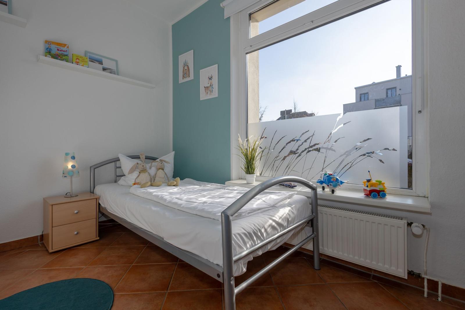 Ein Schlafzimmer mit Bett, Nachttisch und Fenster mit Blick.