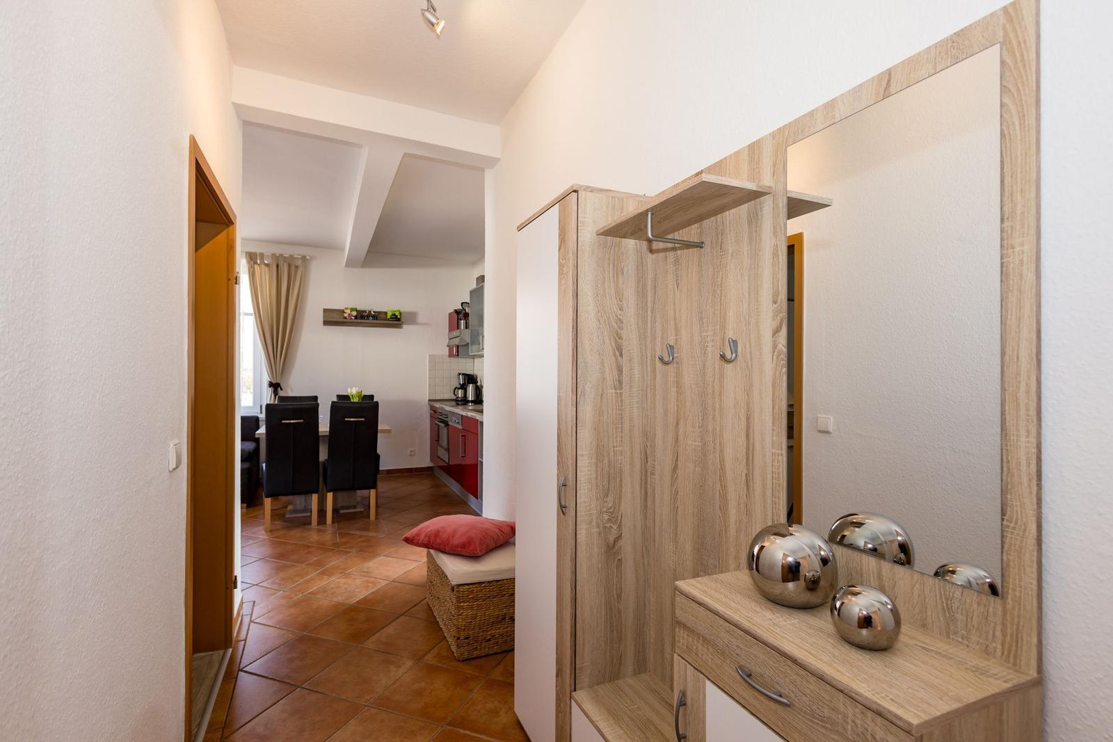 Eingangsbereich mit Garderobe und Spiegel. Durchgang zur Küche und Esszimmer.
