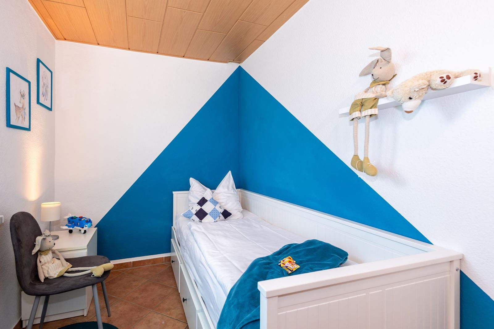 Kinderzimmer mit Bett, Wandgestaltung und Spielzeug