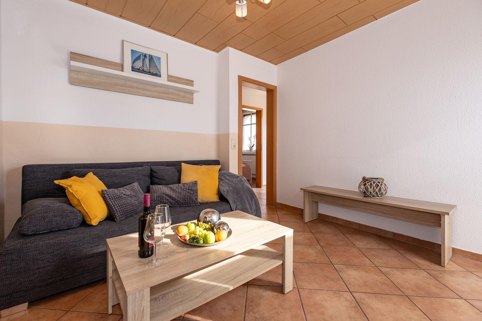 Wohnzimmer mit Sofa, Tisch und Holzdecke.