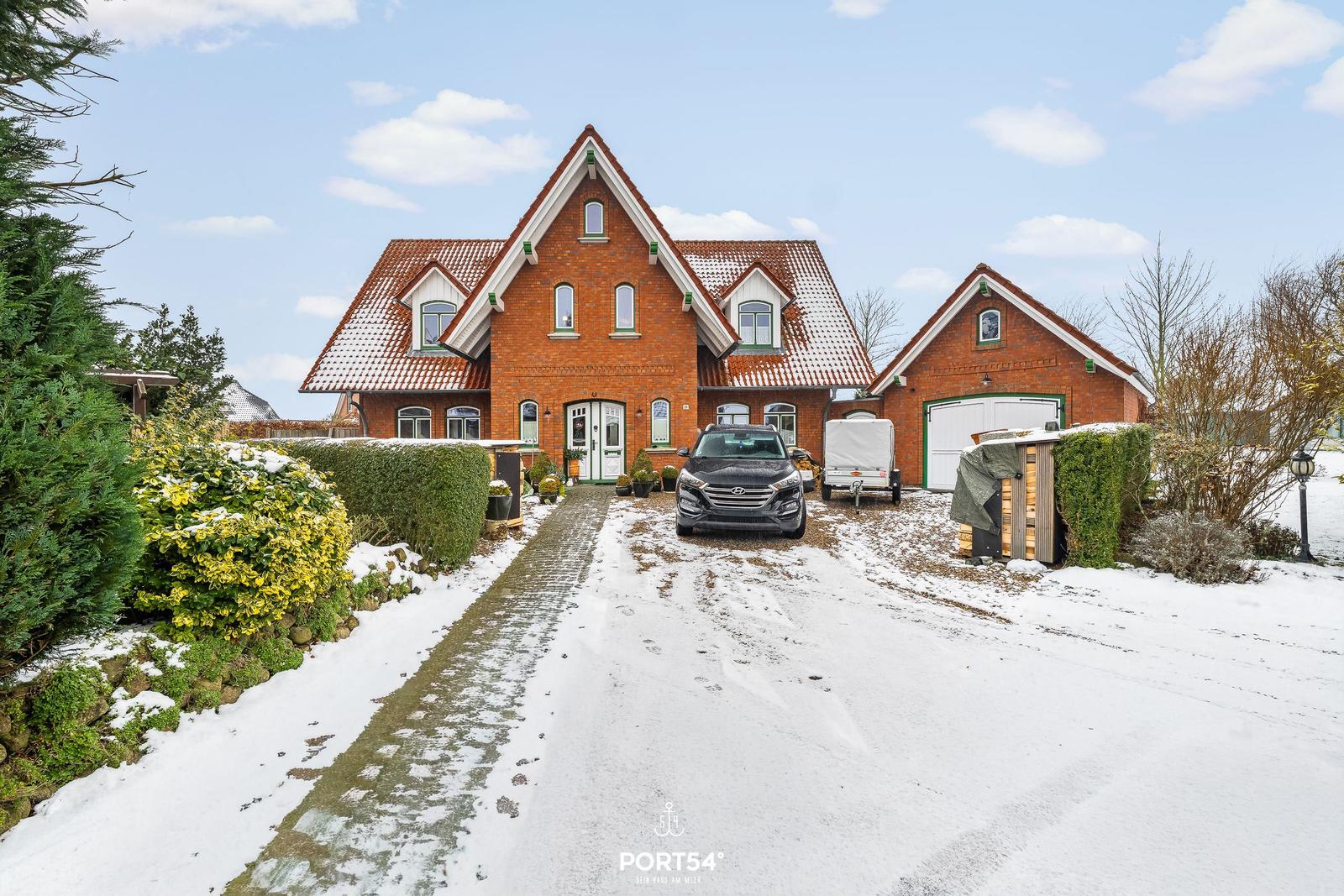 Rotes Backsteinhaus mit Schneebedecktem Dach und Garage