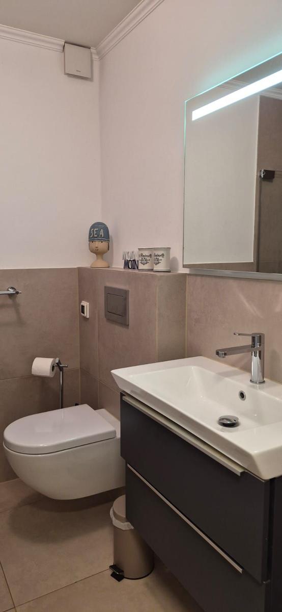 Bad mit Waschbecken, Toilette und Spiegel mit Beleuchtung