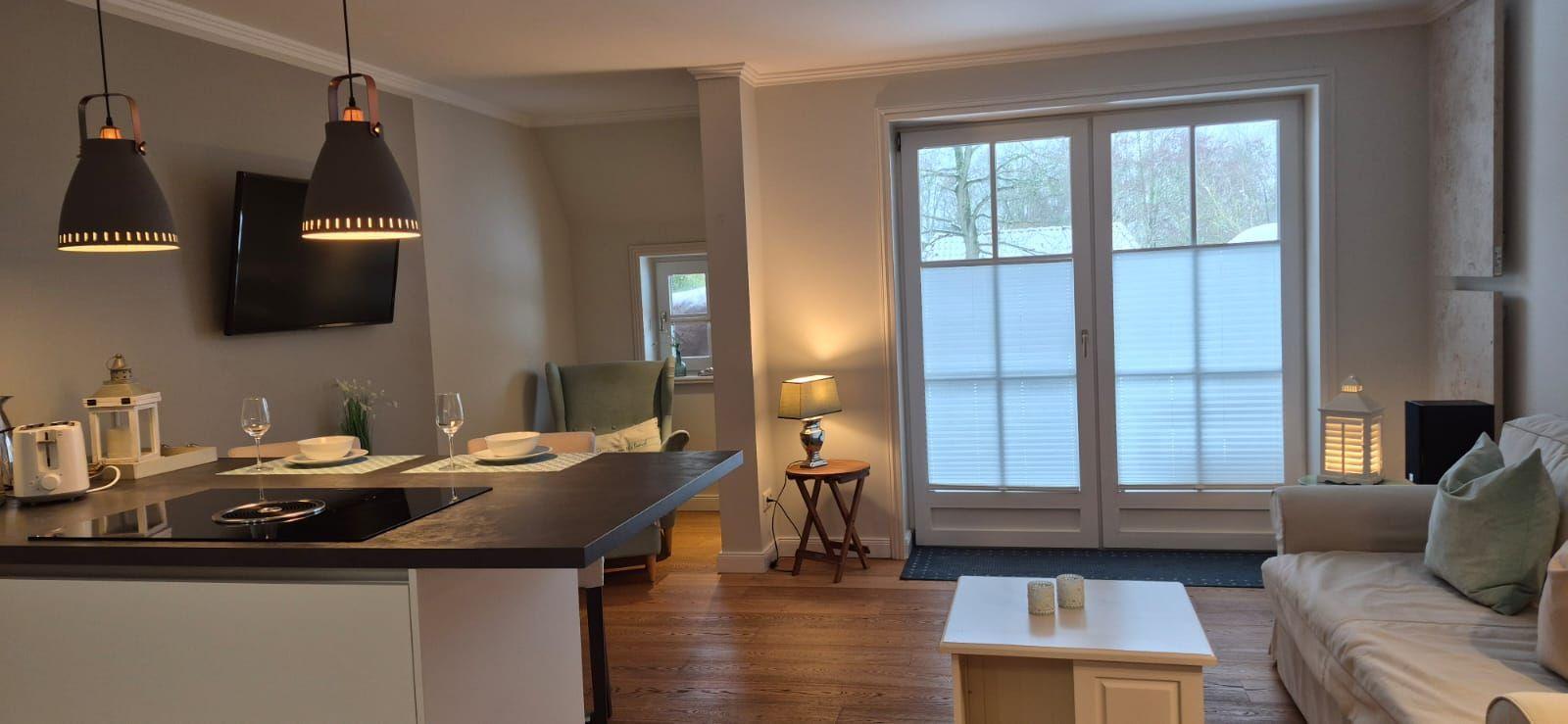 Wohnbereich mit Kücheninsel, Sofa und Fenster zur Aussicht.