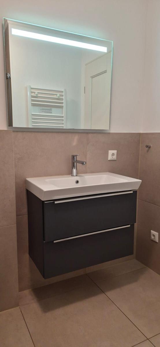 Badezimmer mit Spiegelschrank und Waschbecken