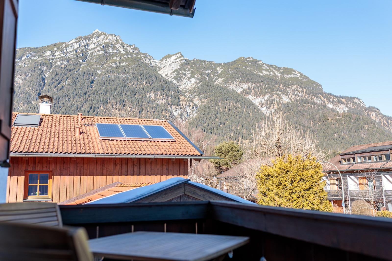 Terrasse mit Tisch und Blick auf Berge und Dächer