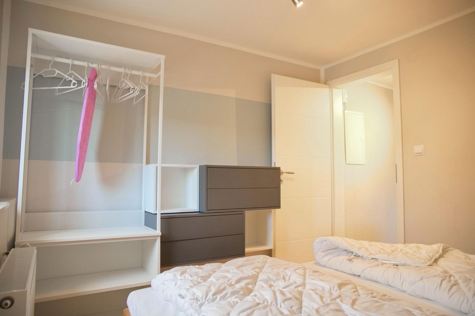 Schlafzimmer mit Bett, Kleiderschrank und Tür