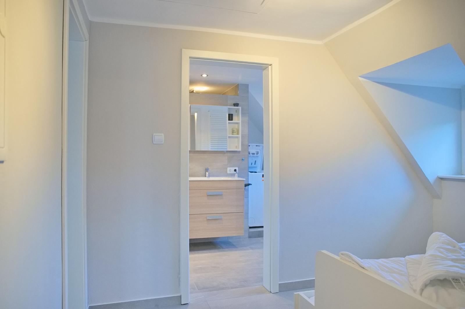 Schlafzimmer mit Blick in das Badezimmer und Dachschräge