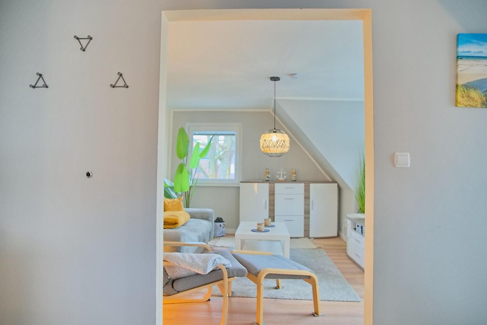 Durchgang in Wohnbereich mit Sofa, Tisch und Deckenfenster