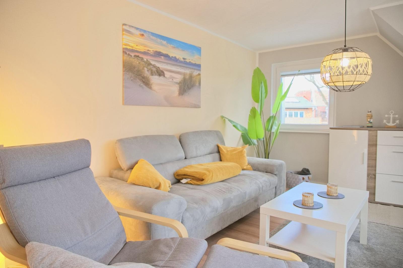 Wohnzimmer mit grauem Sofa, gelben Kissen und Wandbild