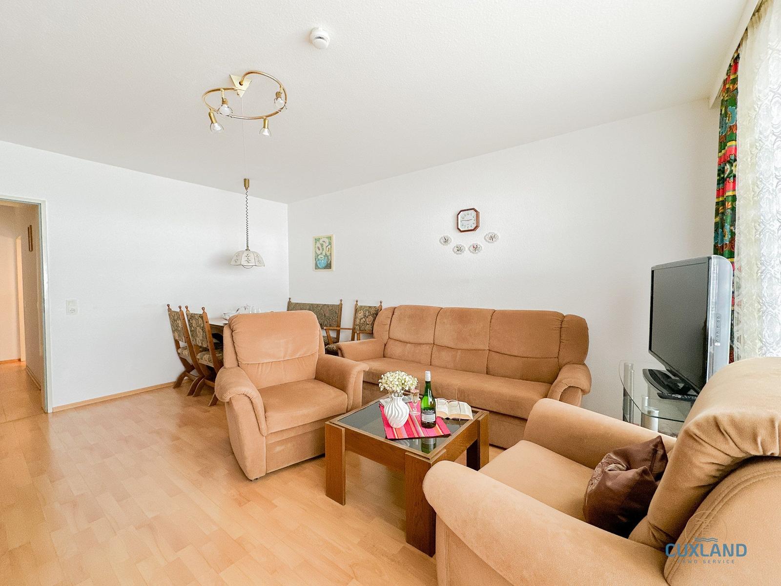 Wohn- und Essbereich mit Sofa, Sessel und Esstisch.