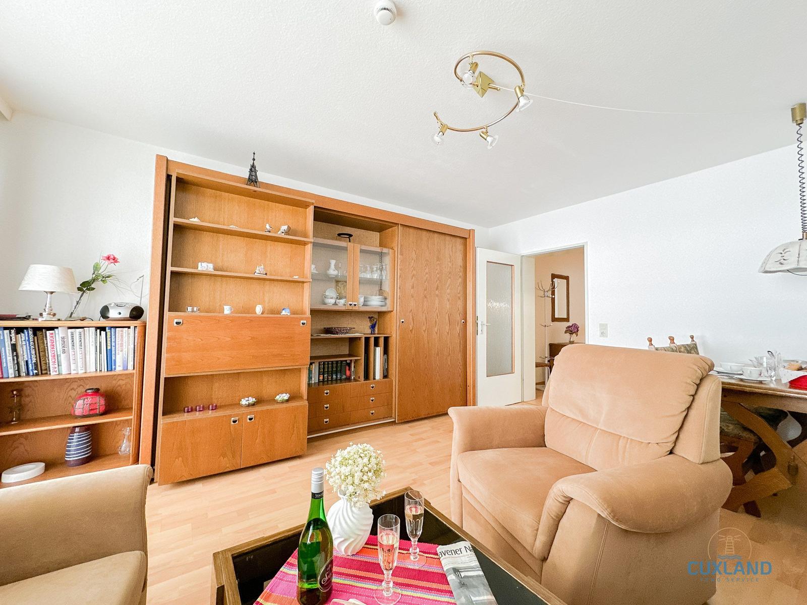 Wohnzimmer mit Holzmöbeln, Sitzgelegenheiten und Tisch mit Getränken.