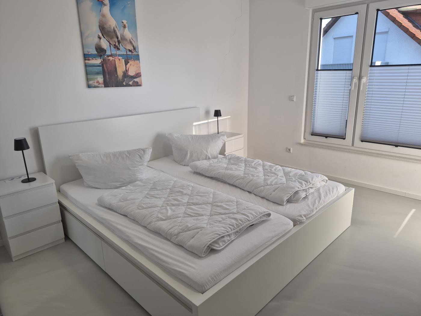 Schlafzimmer mit Doppelbett, Nachttischen und Fenster