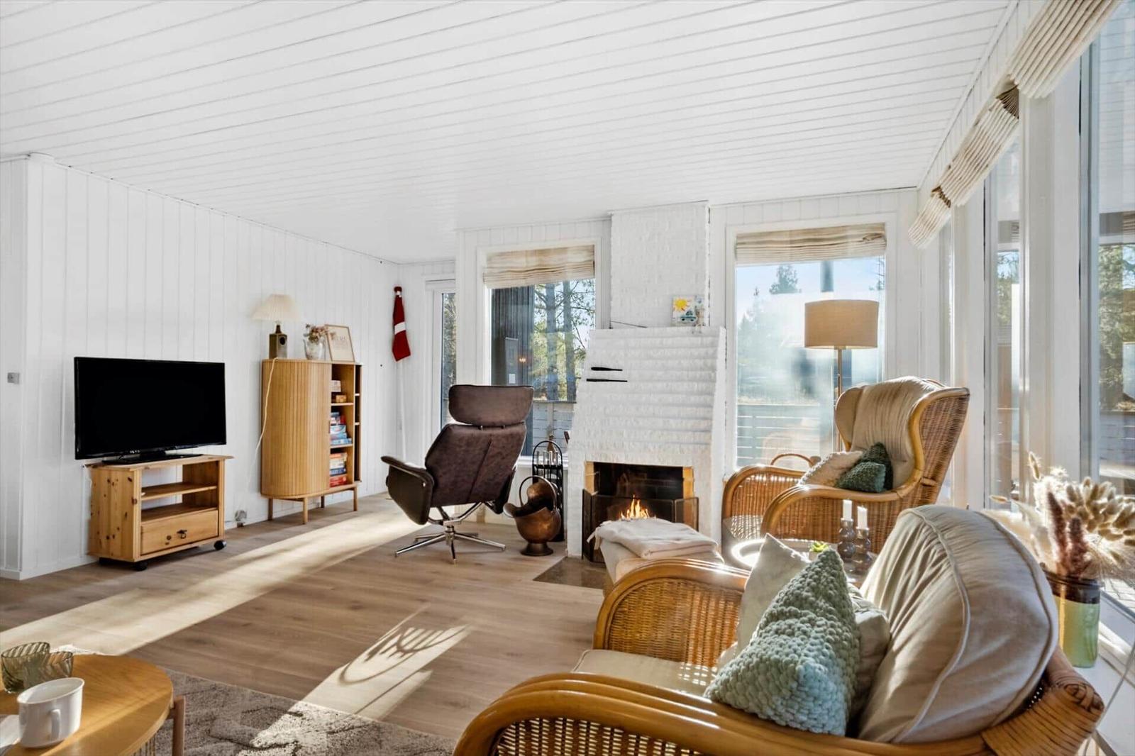 Wohnzimmer mit Kamin, TV und Sitzgelegenheiten.