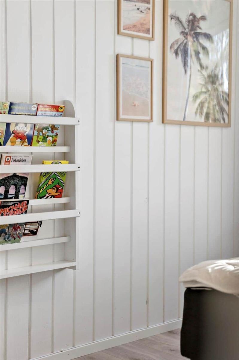 Wand mit Bücherregal und Strandbildern