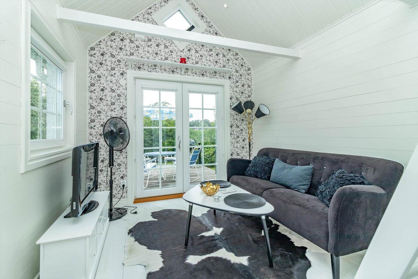 Wohnzimmer mit Sofa, Couchtisch und Terrassentür.