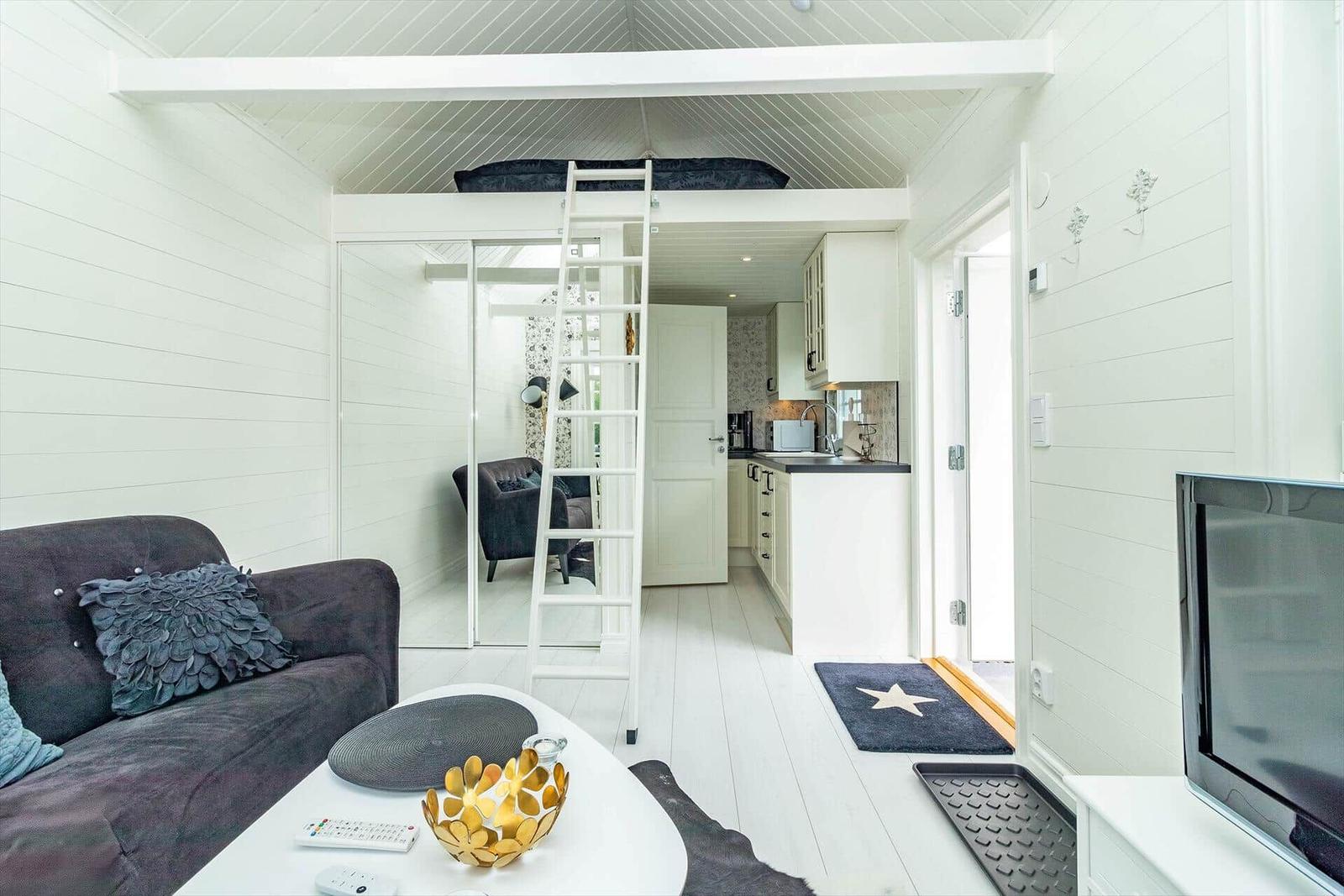 Wohnung mit Schlafbereich oben, Küche und Wohnzimmer mit Sofa.