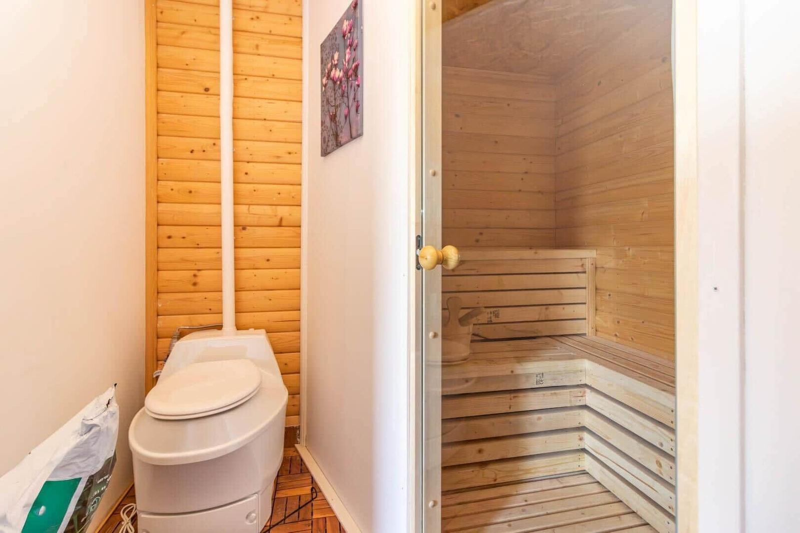 Sauna mit Holzbank und Toilette in angrenzender Wand