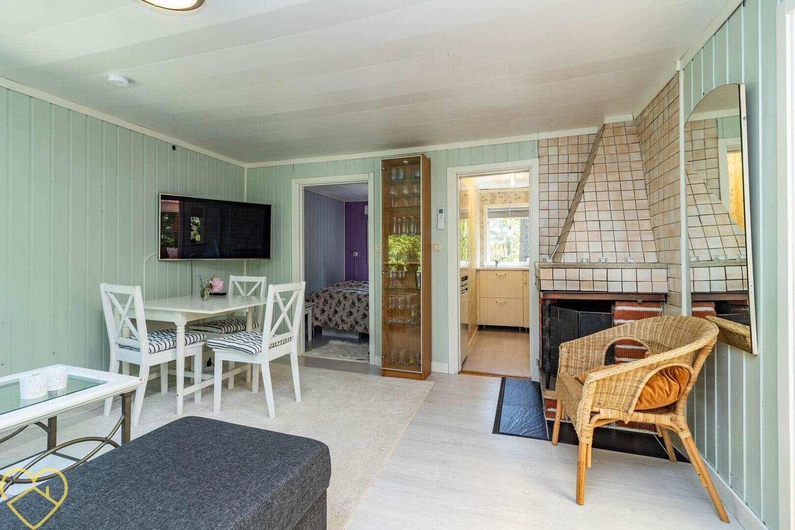 Wohnraum mit Esstisch, Fernseher und Kamin