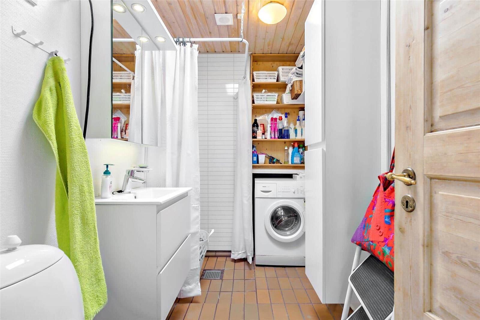 Bathroom with washing machine, shower, and mirror cabinet.