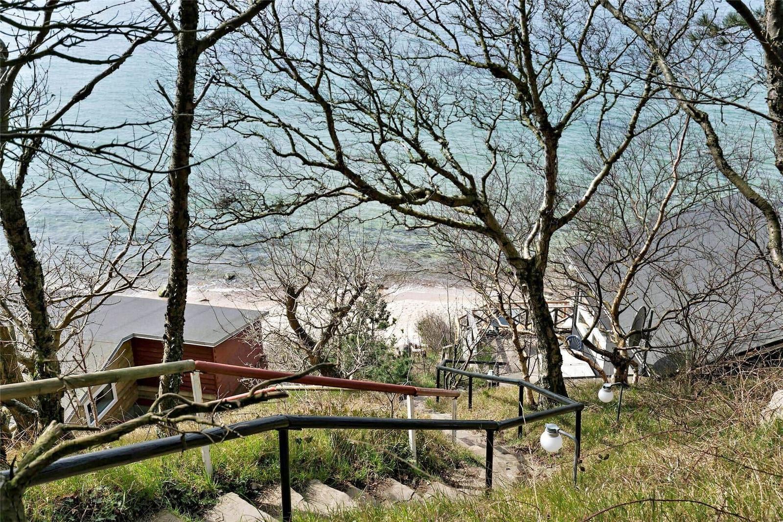Path down to the beach with view of the sea and trees.